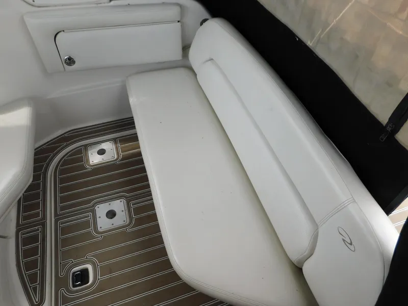 Slide: The Image of 2003 Regal 2860 Commodore boat interior with white seating and wood-patterned flooring. - 21