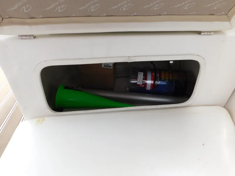 Slide: The Image of Storage compartment in a 2003 Regal 2860 Commodore boat with various items inside. - 24