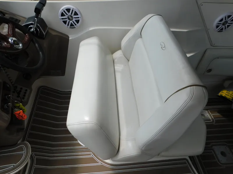 Slide: The Image of Captain's seat on 2003 Regal 2860 Commodore boat, featuring white upholstery and wood-patterned flooring. - 29
