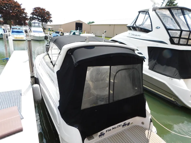 Slide: The Image of 2003 Regal 2860 Commodore boat docked with black canopy, surrounded by other boats. - 3