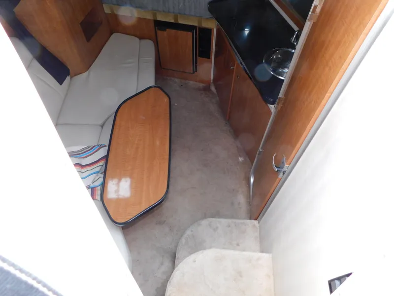 Slide: The Image of 2003 Regal 2860 Commodore cabin interior with sofa, table, and kitchenette. - 44
