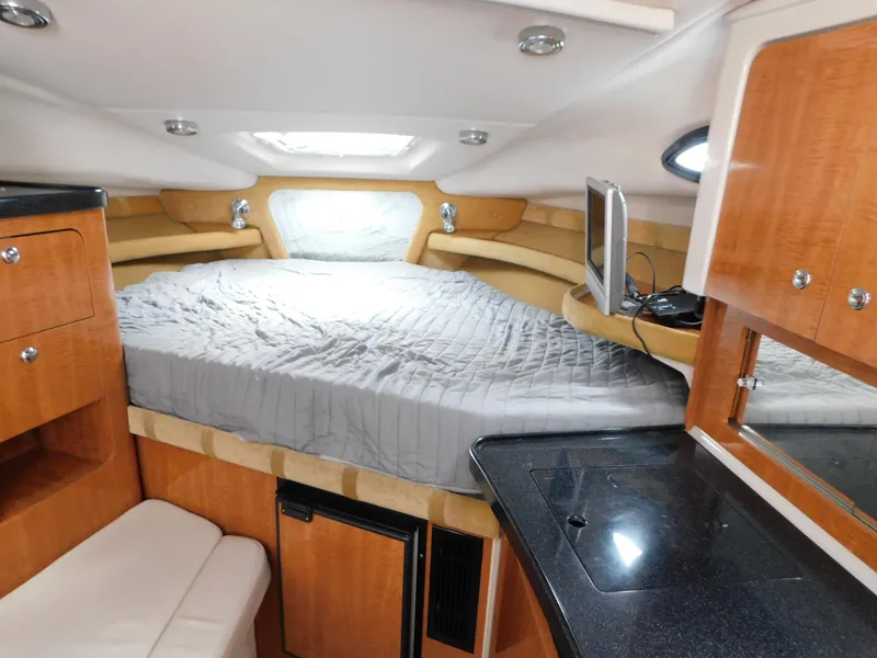 Slide: The Image of 2003 Regal 2860 Commodore cabin interior with bed, kitchenette, and wood cabinetry. - 47