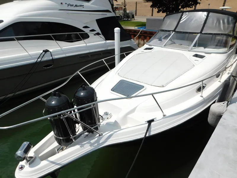 Slide: The Image of 2003 Regal 2860 Commodore boat docked in marina, sleek white design, covered cockpit. - 7