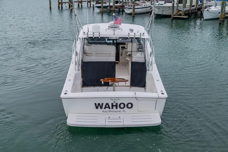 Slide: The Image of 2009 Tiara Yachts 39 Open boat docked, rear view with "WAHOO" name and American flag. - 17