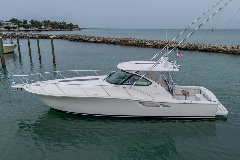 Slide: The Image of 2009 Tiara Yachts 39 Open cruising in calm waters near a rocky shoreline. - 19