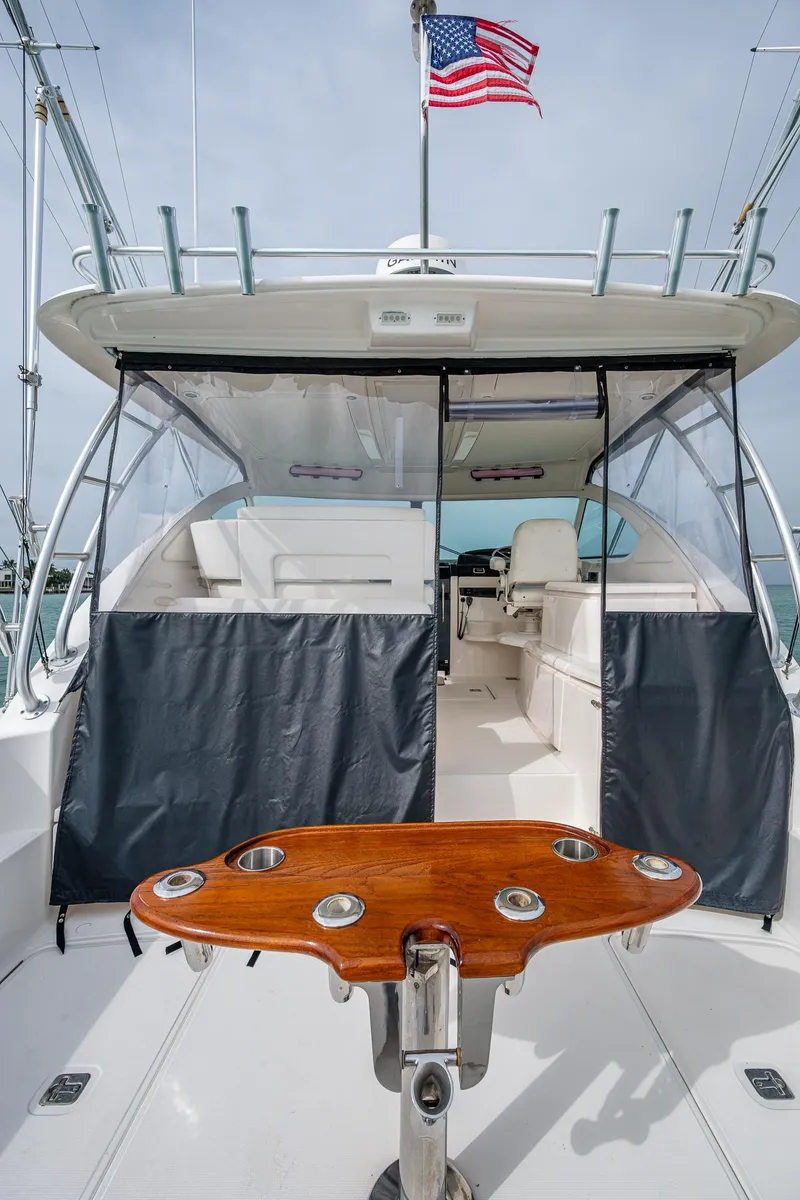 Slide: The Image of 2009 Tiara Yachts 39 Open with American flag, featuring spacious deck and seating area. - 36