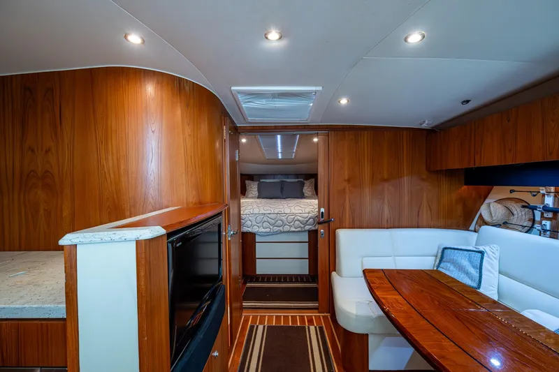Slide: The Image of 2009 Tiara Yachts 39 Open interior with wood finish, cozy seating, and modern amenities. - 50