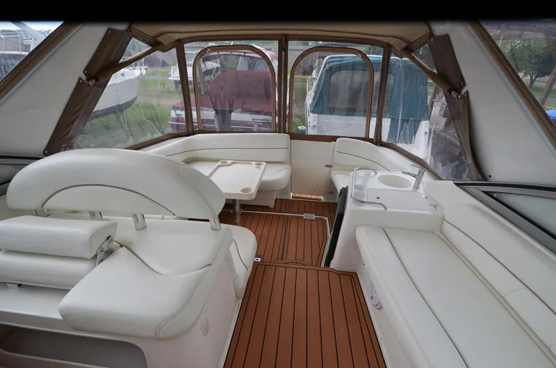 Slide: The Image of 2002 Larson 330 Cabrio boat interior with white seating and wood flooring. - 11