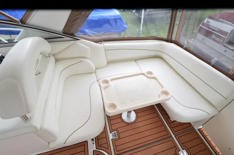 Slide: The Image of 2002 Larson 330 Cabrio boat interior with white seating and wooden flooring. - 12