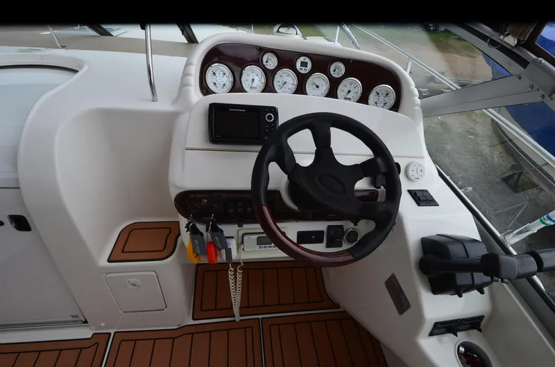 Slide: The Image of 2002 Larson 330 Cabrio boat dashboard with steering wheel and instrument panel. - 14