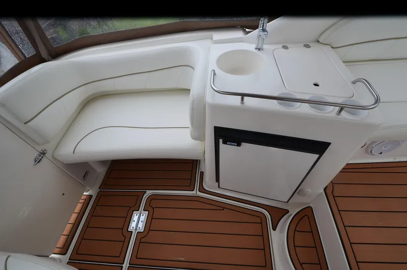 Slide: The Image of 2002 Larson 330 Cabrio boat interior with white seating and wood flooring. - 17