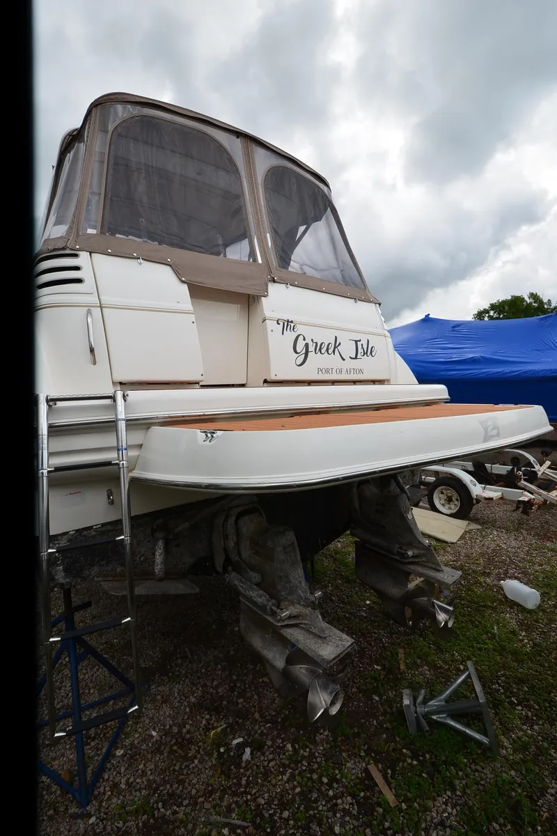 Slide: The Image of 2002 Larson 330 CABRIO boat with covered cockpit, parked outdoors. - 20