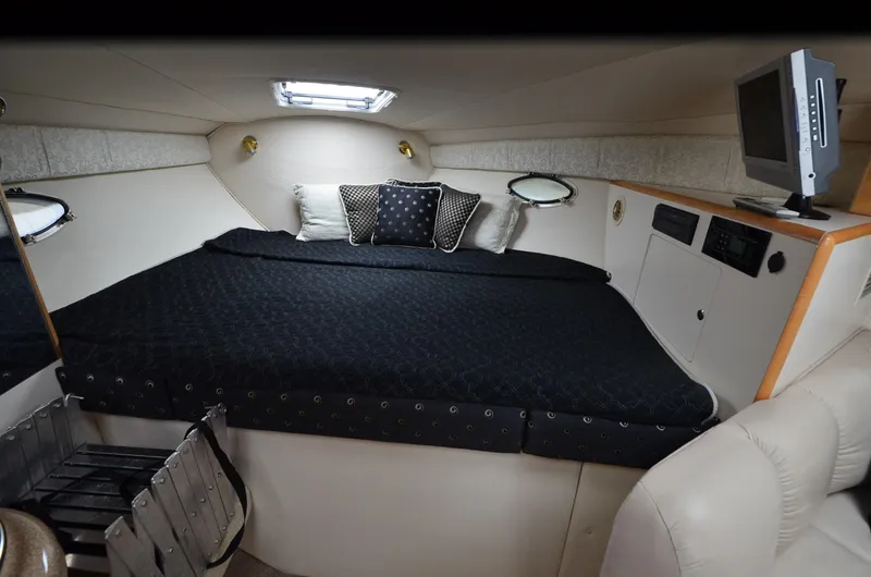 Slide: The Image of Interior of 2002 Larson 330 Cabrio boat with cozy bed and TV. - 5