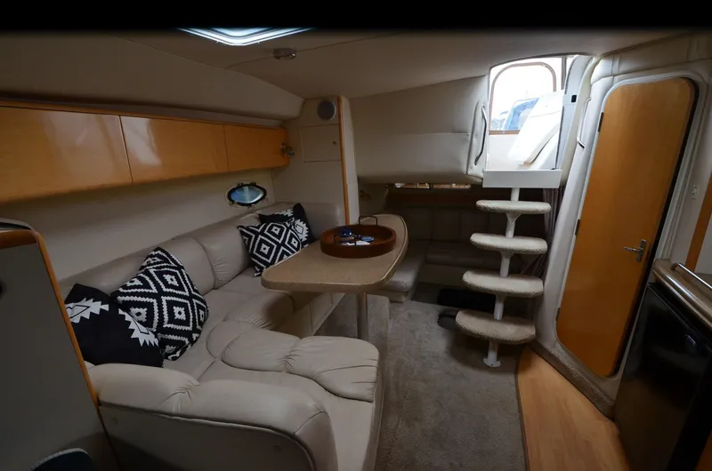 Slide: The Image of 2002 Larson 330 Cabrio cabin interior with seating, table, and stairs. - 6
