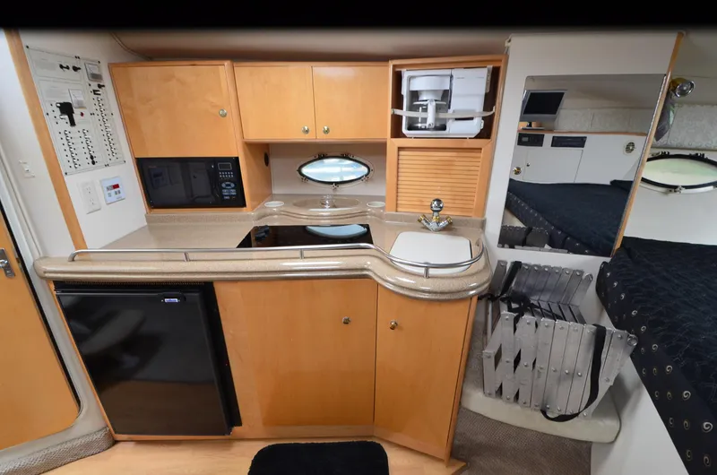 Slide: The Image of 2002 Larson 330 CABRIO interior kitchen with wood cabinets, sink, and appliances. - 7