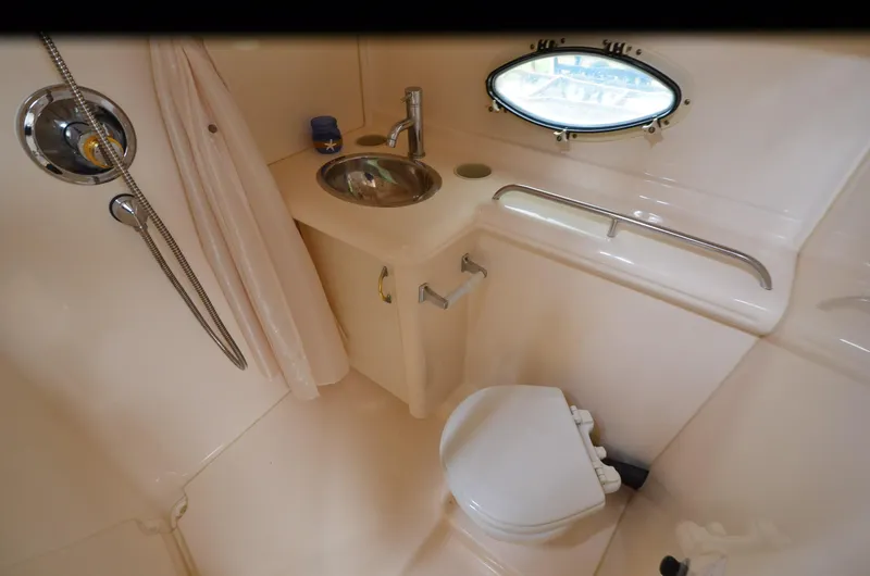 Slide: The Image of 2002 Larson 330 CABRIO boat bathroom with sink, toilet, shower, and porthole window. - 8