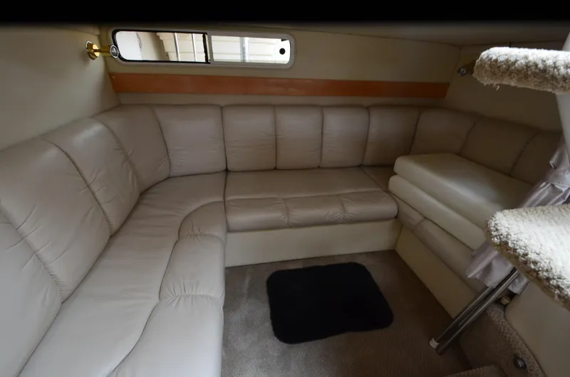 Slide: The Image of Interior of 2002 Larson 330 CABRIO boat with beige leather seating and carpeted floor. - 9