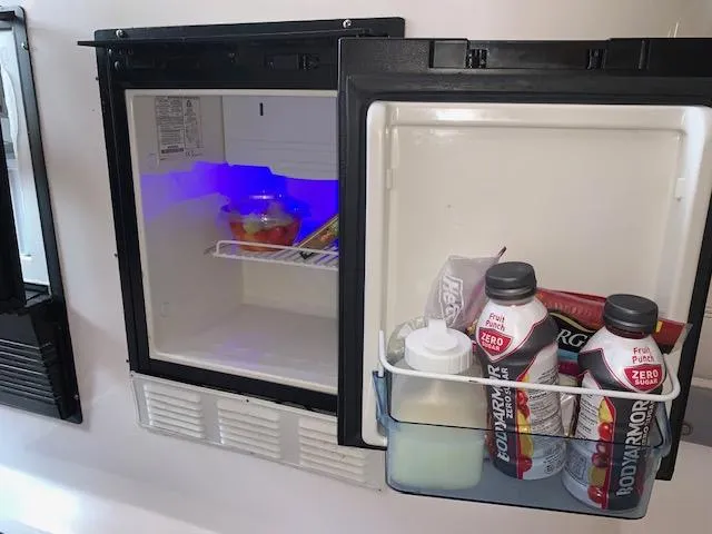 Slide: The Image of Mini fridge stocked with drinks and snacks inside a 2000 Donzi 38 ZX boat. - 10