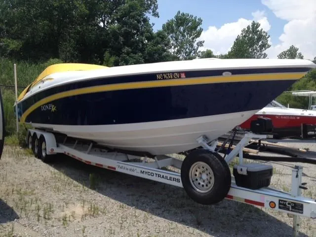 Slide: The Image of 2000 Donzi 38 ZX speedboat on trailer, blue and yellow design, parked outdoors. - 14