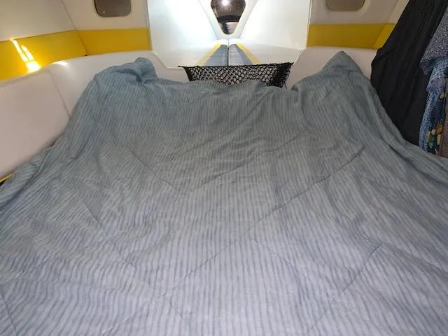 Slide: The Image of Interior cabin of a 2000 Donzi 38 ZX boat with a striped bedspread. - 17
