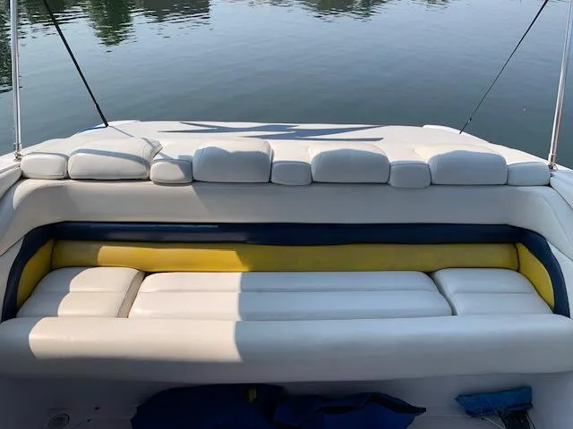 Slide: The Image of 2000 Donzi 38 ZX boat interior with white and yellow seating, calm water backdrop. - 6