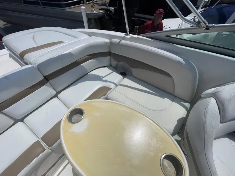 Slide: The Image of 2005 Chaparral 236SSi boat interior with white and beige seating, round table with cup holders. - 17