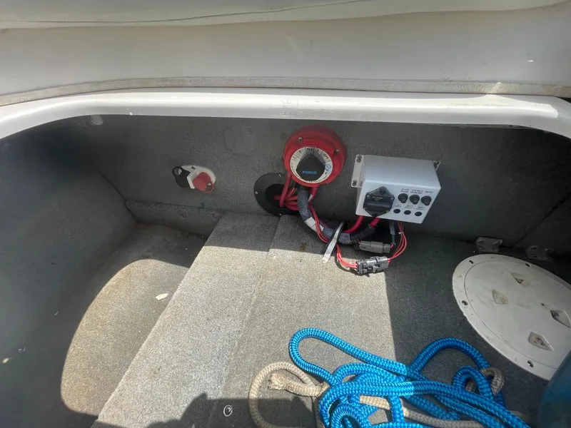 Slide: The Image of Storage compartment of a 2005 Chaparral 236SSi boat with ropes and electrical components. - 22