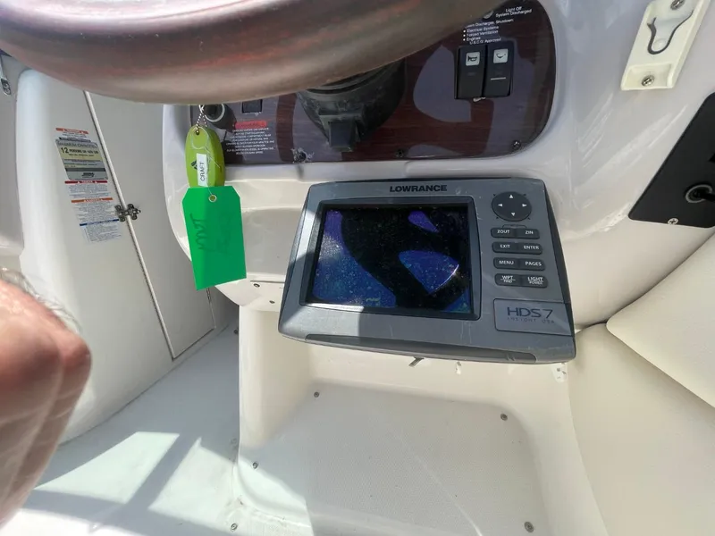 Slide: The Image of 2005 Chaparral 236SSi boat dashboard with Lowrance HDS-7 display and green key tag. - 8