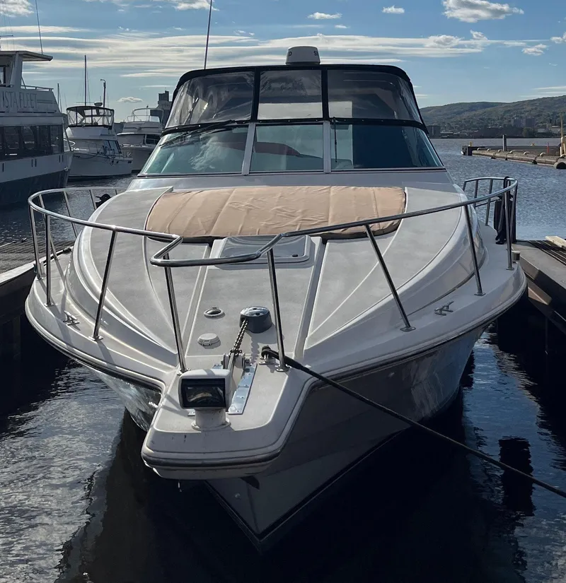 Slide: The Image of 2000 Trojan 400 Express Yacht docked at marina, front view, clear sky. - 10