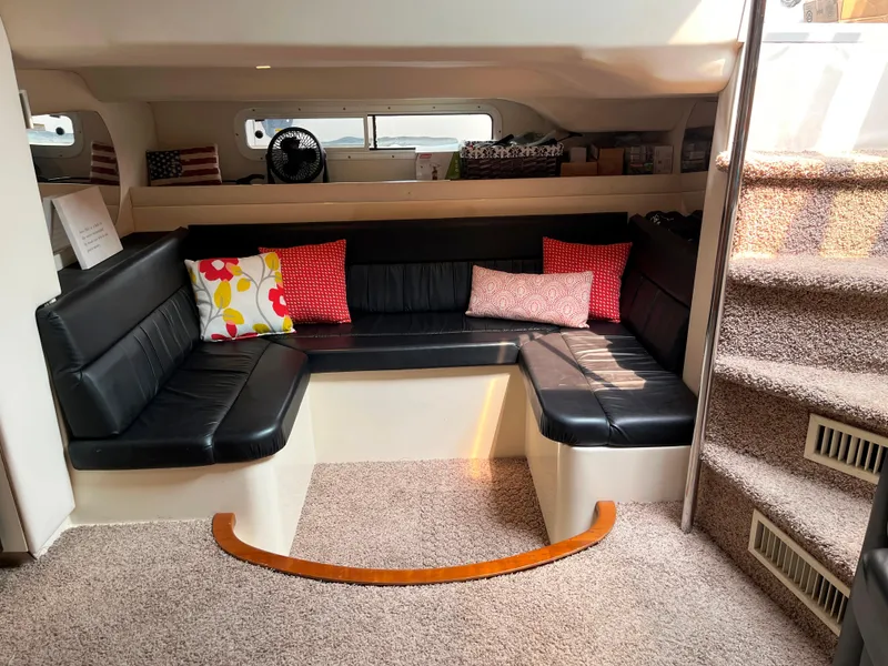 Slide: The Image of Interior of 2000 Trojan 400 Express Yacht with black seating and colorful cushions. - 4