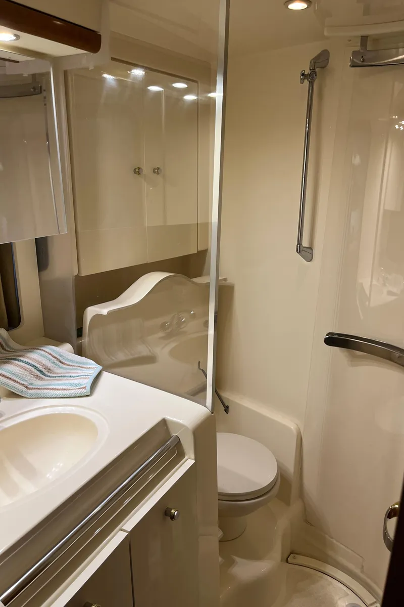 Slide: The Image of 2000 Trojan 400 Express Yacht bathroom with shower, sink, and toilet. - 8