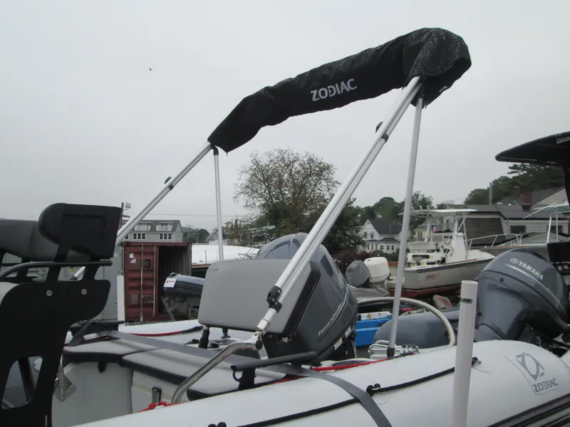 Slide: The Image of 2020 Zodiac Open 5.5 boat with canopy, docked in a marina setting. - 3