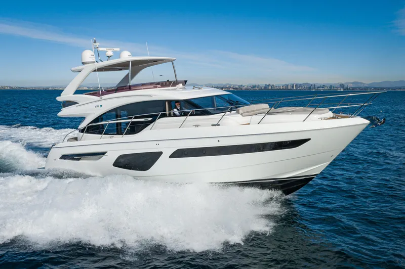 Slide: The Image of 2022 Princess F55 yacht cruising on open water under clear blue skies. - 1