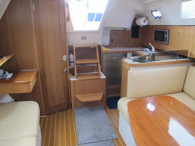 Slide: The Image of Interior of 2015 Catalina 315 sailboat with wood finish and compact kitchen area. - 6