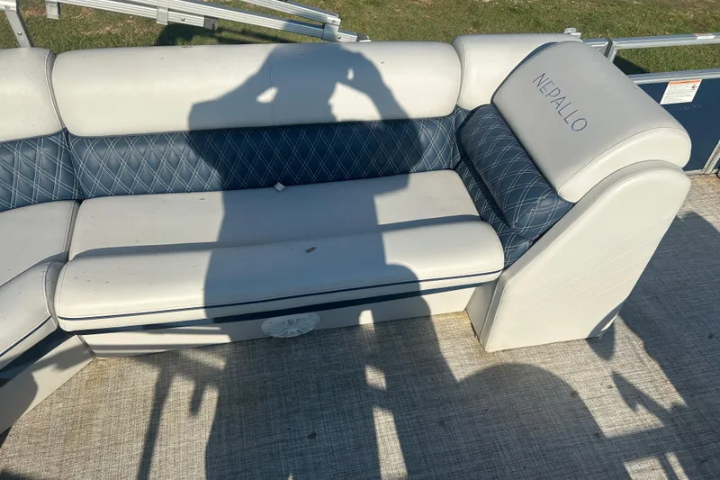 Slide: The Image of 2023 Nepallo 22TL Sport Toon boat seating with blue and white upholstery, shadow cast on cushions. - 12