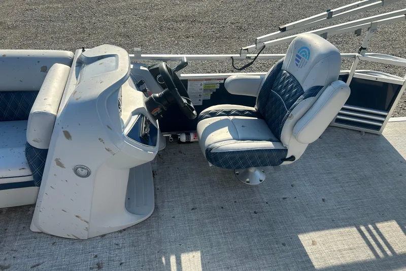 Slide: The Image of 2023 Nepallo 22TL Sport Toon boat interior with steering console and cushioned seat. - 2