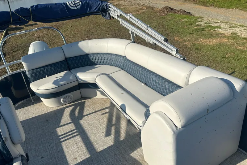 Slide: The Image of 2023 Nepallo 22TL Sport Toon boat with white and blue seating, docked on grassy shore. - 3