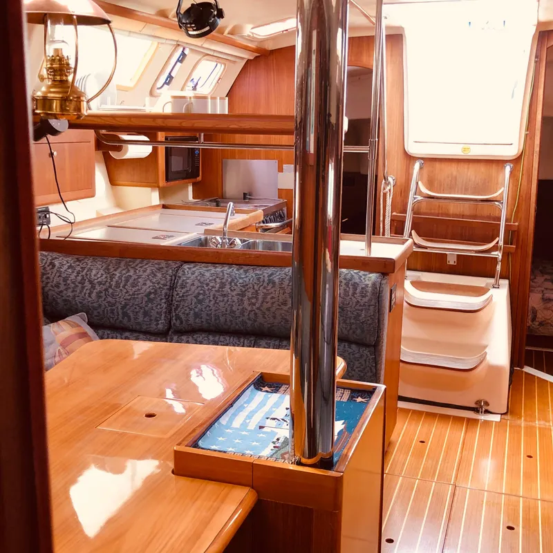 Slide: The Image of Interior of a 2000 Hunter 410 sailboat with wood finish and cozy seating area. - 14