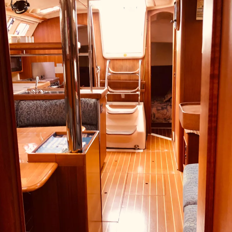 Slide: The Image of Interior of a 2000 Hunter 410 sailboat with wooden flooring and cozy seating. - 15