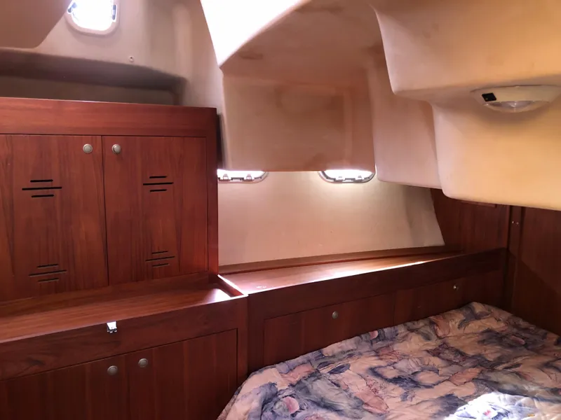 Slide: The Image of Cozy cabin interior of a 2000 Hunter 410 sailboat with wooden cabinets and bedding. - 21