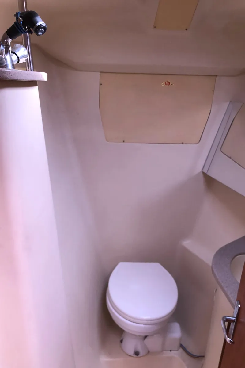 Slide: The Image of Compact bathroom in a 2000 Hunter 410 sailboat, featuring a toilet and sink. - 29
