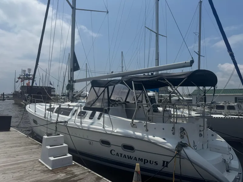 Slide: The Image of Sailboat "Catawampus II" docked, Hunter 410 model, year 2000, under a cloudy sky. - 32