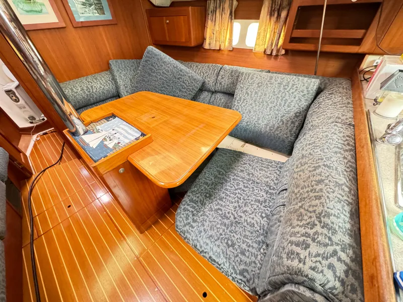 Slide: The Image of Cozy interior of 2000 Hunter 410 sailboat with wooden table and patterned seating. - 36