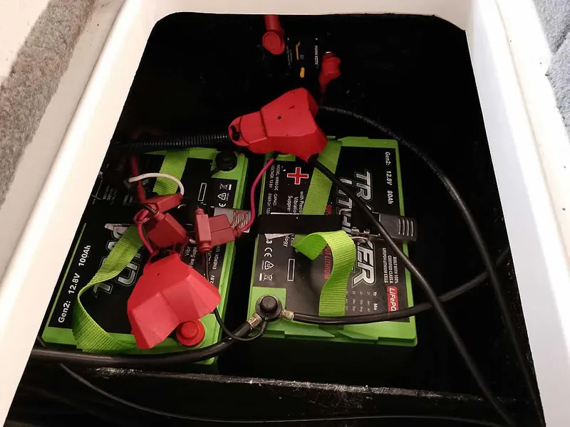 Slide: The Image of 2021 Ranger Z519 SC boat batteries with red and green connectors in storage compartment. - 38