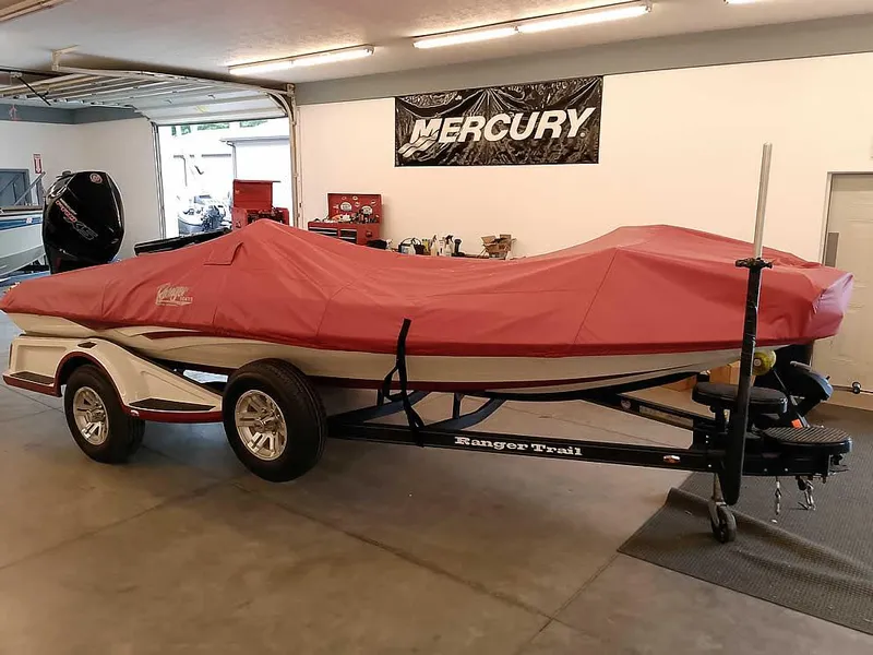 Slide: The Image of 2021 Ranger Z519 SC boat with red cover on trailer in garage. - 42