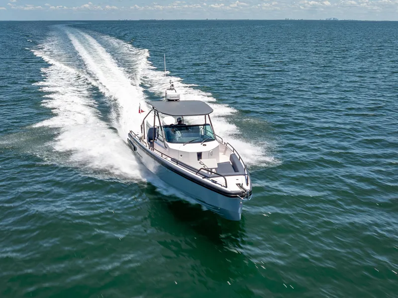 Slide: The Image of 2022 Axopar 28 T-Top Brabus cruising on open water, leaving a wake behind. - 16