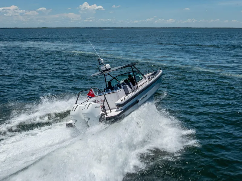 Slide: The Image of 2022 Axopar 28 T-Top Brabus speeding on open water, creating waves. - 18