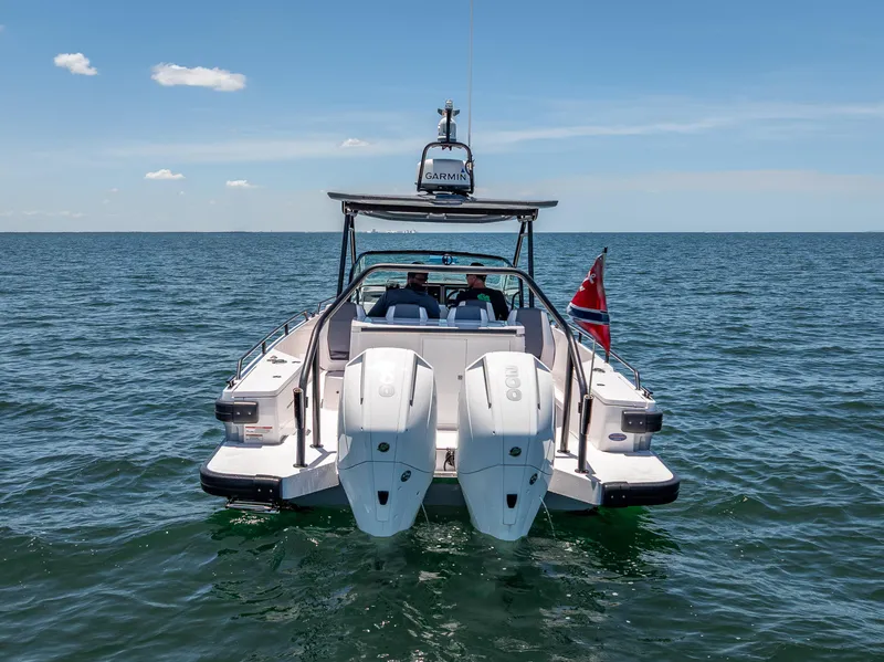 Slide: The Image of 2022 Axopar 28 T-Top Brabus boat on open water, rear view. - 2