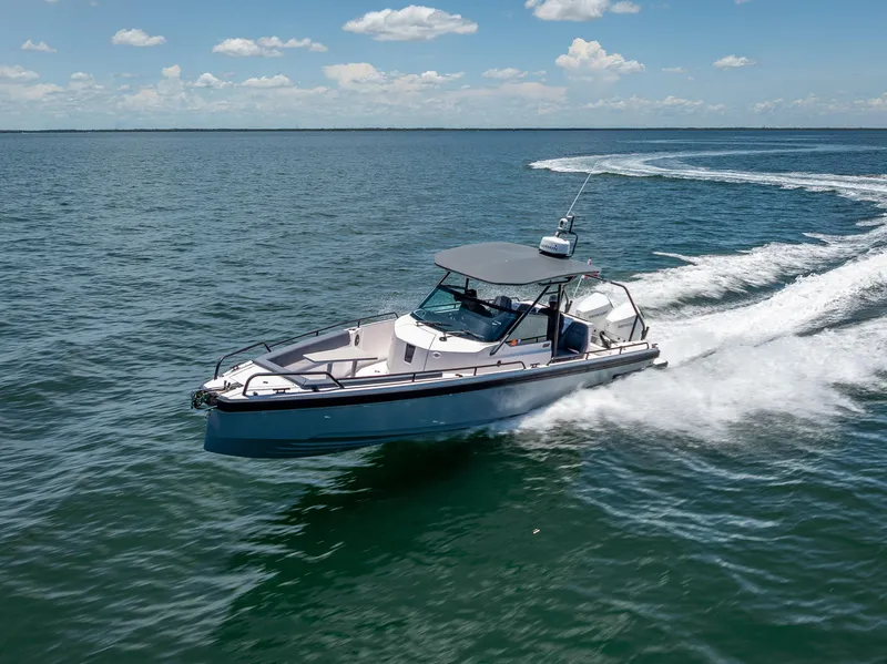 Slide: The Image of 2022 Axopar 28 T-Top Brabus cruising on open water under a clear sky. - 21