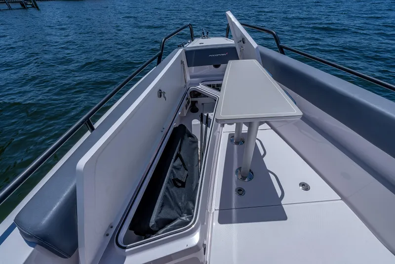 Slide: The Image of 2022 Axopar 28 T-Top Brabus boat interior with seating and table on the water. - 26
